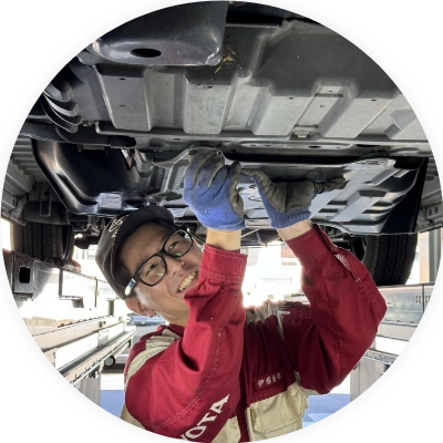 車の底面を整備する男性 写真